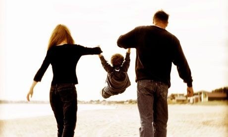 her er et billede af en mor og far, som leger med barnet, mens de går tur på stranden